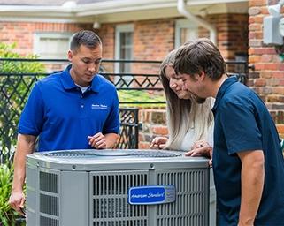HVAC Technician and Homeowners at an Outdoor Unit